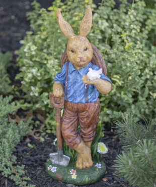 Tall Easter man statue standing holding a shovel in one hand and a white bird in the other