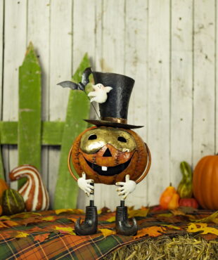 A pumpkin with a gold mask and a top hat with with a ghost and bat attached