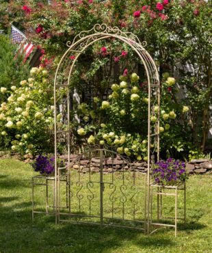 Iron Garden gate archway with 2 side Plant Stands with flowers on them in distressed antique white finish in garden